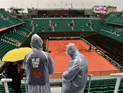 Tres espectadores con impermeables en la pista central.