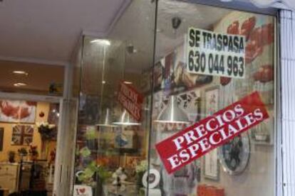 Un cartel ofrece precios especiales en el escaparate de una tienda de muebles y decoración que se traspasa. EFE/Archivo