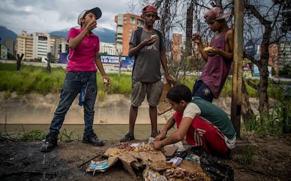 Un grupo de niños busca comida entre bolsas de basura en Caracas el pasado noviembre.