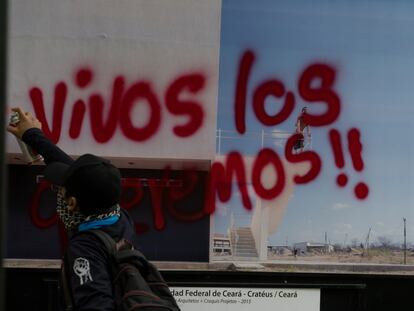 Un manifestante pinta por encima de una fotografía: "Vivos los queremos!!", en 2022.