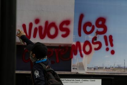 Un manifestante pinta por encima de una fotografía: "Vivos los queremos!!".