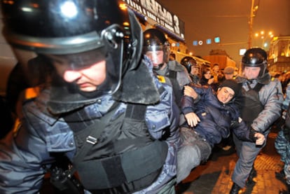 Policías antidisturbios detienen a un activista de la oposición en Moscú.