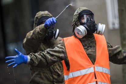 Miembros de la UME se descontaminan tras la desinfección de un centro de mayores en Vigo.