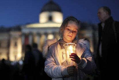 Una niña sostiene una vela durante la vigilia en Trafalgar Square.