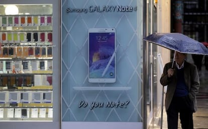 Un hombre junto a una tienda con un anuncio del Samsung Galaxy.