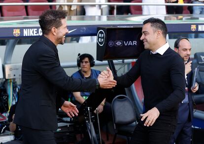 El entrenador del Atlético de Madrid, Diego Simeone, saluda a Xavi, entrenador del FC Barcelona, momentos antes del comienzo del partido en el Camp Nou. 