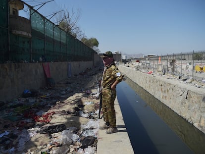Restos de ropa ensangrentada tras el atentado a las puertas del aeropuerto de Kabul, este jueves, junto a un talibán.