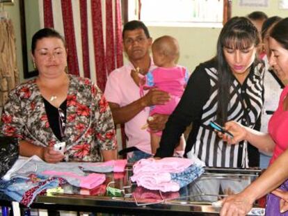 Vecinos de Concepci&oacute;n (Colombia) compran en un comercio con el tel&eacute;fono m&oacute;vil. 