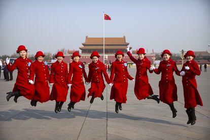 Azafatas de autobuses saltan mientras posan para una foto de grupo en la plaza de Tiananmen durante una sesión plenaria del congreso popular nacional en Pekín. (China).
