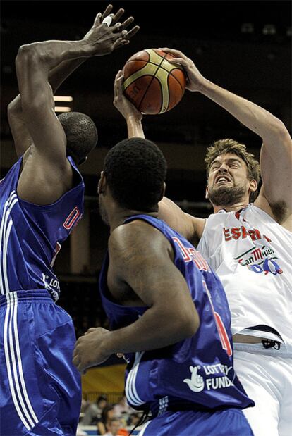 Marc Gasol lanza a canasta ante la oposición de dos jugadores británicos.