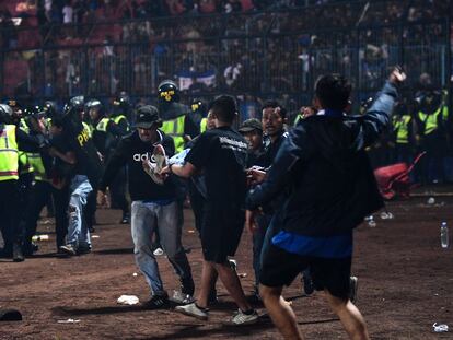 Los aficionados intentaban evacuar a algunas víctimas tras el partido entre el Arema FC y el Persebaya Surayaba, el sábado en la isla indonesia de Java.