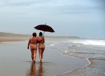 Nudists take part in the annual North East Skinny Dip at sunrise at Druridge Bay, near Ashington, Northumberland, northeast England on September 25, 2016.  
Hundreds of nude bathers braved the cold in the annual skinny-dip. / AFP PHOTO / SCOTT HEPPELL