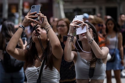 Dos turistas  toman fotos frente a la Casa Batlló, en Barcelona.