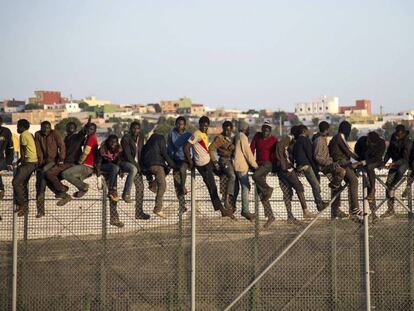 Inmigrantes encaramados en la valla de Melilla.
