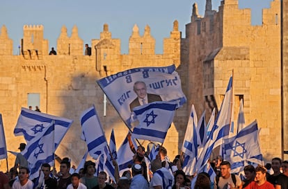 Israelenses hasteiam bandeiras do lado de fora da Porta de Damasco na Cidade Velha de Jerusalém, em 15 de junho de 2021, comemorando o aniversário da ocupação israelense de 1967 de Jerusalém Oriental. 