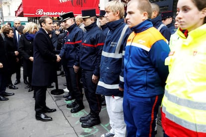 El presidente Emmanuel Macron y su esposa, Brigitte, saludan a miembros de los servicios de emergencia delante del bar "Comptoir Voltaire" durante la ceremonia por el 2º aniversario de los atentados de París (Francia).