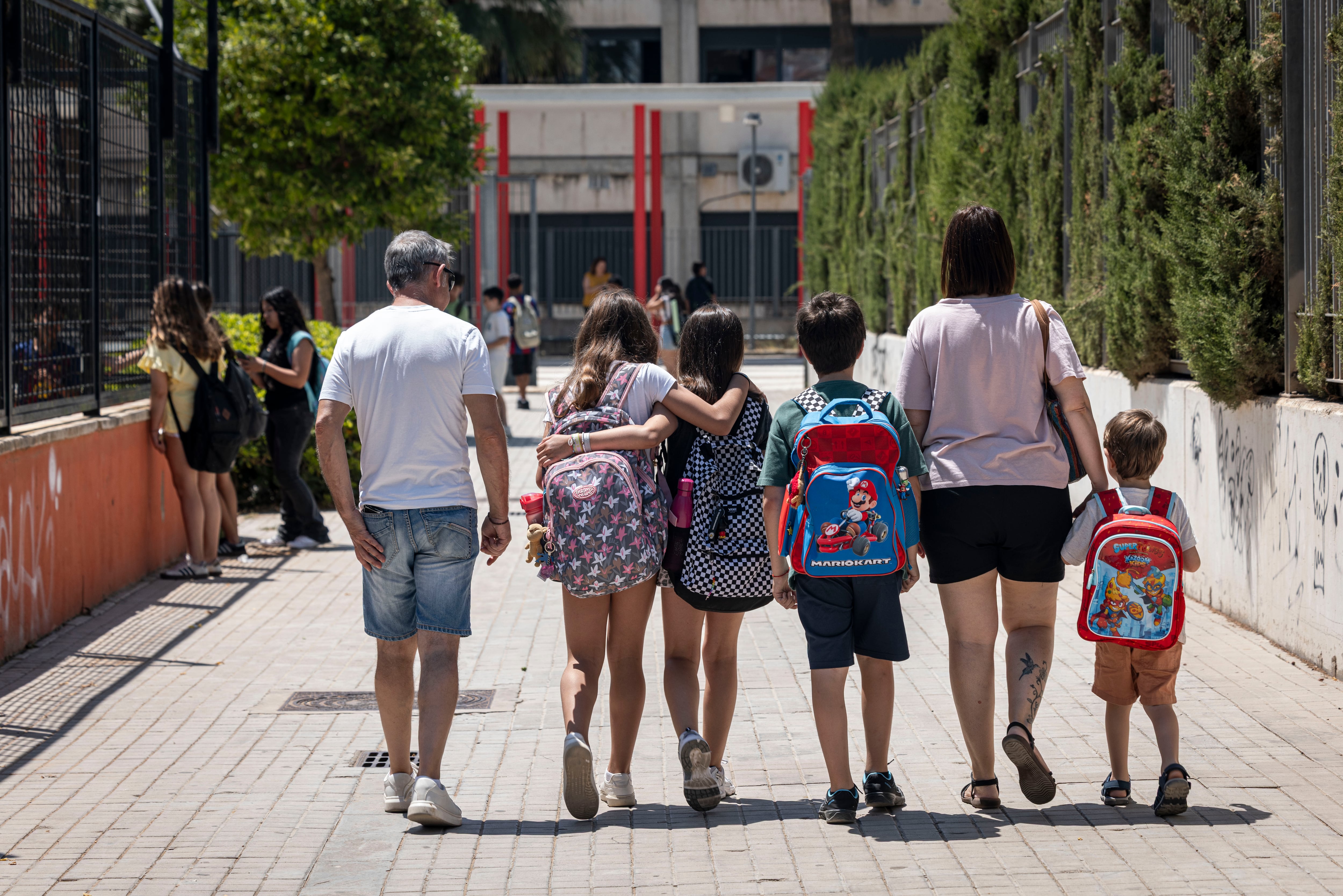 Alumnos de primaria con sus padres, en el barrio de Malilla, Valencia, este lunes.