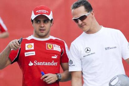 Michael Schumacher (a la derecha) habla con Felipe Massa.