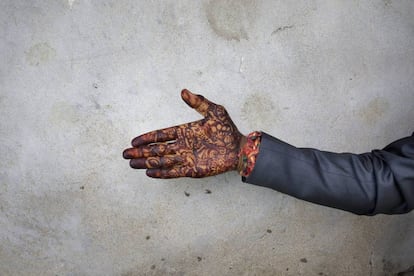 Un novio muestra su mano pintada con henna antes del comienzo de una boda múltiple en Bhopal, India.