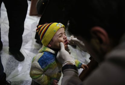 Un niño sirio recibe una dosis de una vacuna en el barrio de Duma, cerca de Damasco. Aviones de combate han bombardeado en dos ocasiones los alrededores de Duma, al noreste de Damasco, en los primeros ataques allí desde que entró en vigor el cese de hostilidades el pasado sábado, según ha informado el Observatorio Sirio para los Derechos Humanos.