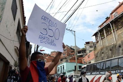 Un manifestante sostiene un cartel de protesta: "Artículo 350. ¡Abajo la dictadura!". El alzamiento y las posteriores protestas llegan después de que la Asamblea Nacional, dominada por la oposición, aprobara una resolución para declarar una amnistía a todos los efectivos militares que hayan participado en actividades represivas y de orden público obedeciendo órdenes superiores.