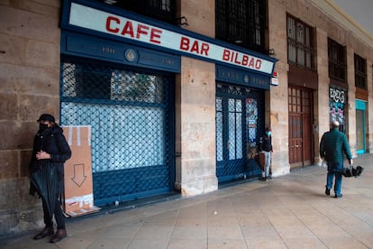 Varias personas pasan por delante de un café cerrado en la plaza Nueva de Bilbao, el pasado vienes.
