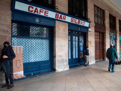 Varias personas pasan por delante de un café cerrado en la plaza Nueva de Bilbao, el pasado vienes.