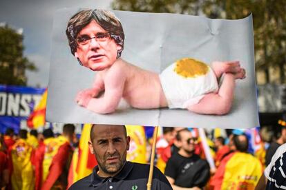 Un hombre lleva una imagen de Carles Puigdemont, en un momento del manifestación.
