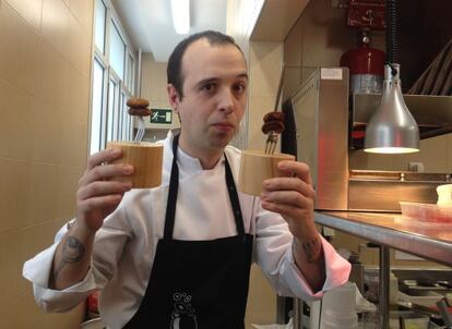 Edorta Lamo, cocinero de la tasca donostiarra A Fuego Negro, en su cocina temporal de Madrid, con dos pinchos de 'black rabas'.