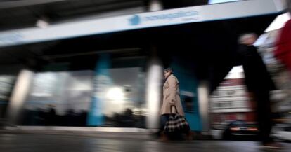 Una mujer camina frente a una sucursal de Novagalicia Banco