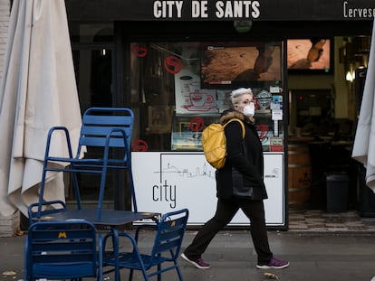 Una mujer pasa ante la terraza de un bar en una calle de Barcelona, el pasado febrero.