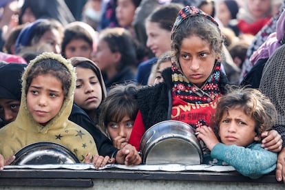 Ni?os palestinos esperan recibir comida de ayuda humanitaria este viernes en Jan Yunis, en el sur de la Franja.