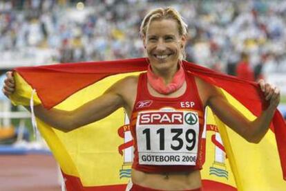 Marta Domínguez posa con la bandera española tras su victoria en los 5.000 metros.