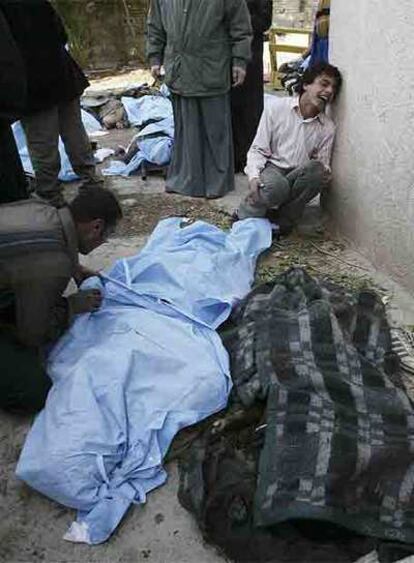 Varios iraquíes lloran sobre los cadáveres de sus familiares muertos en los atentados de ayer en Bagdad.