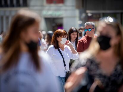 Un grupo de personas con y sin mascarillas por el centro de Madrid.