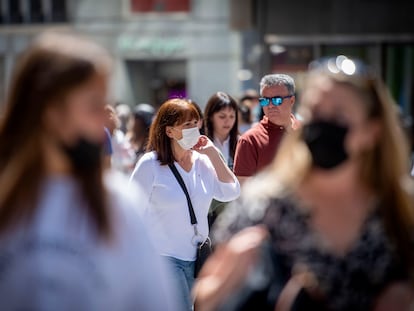 Grupo de personas con y sin mascarillas por el centro de Madrid.