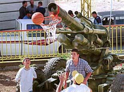 Una pieza de artillería dejada por los israelíes en Líbano es utilizada por jóvenes libaneses para jugar al baloncesto.