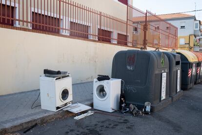 Lavadoras abandonadas junto a unos contenedores en una calle de Madrid.