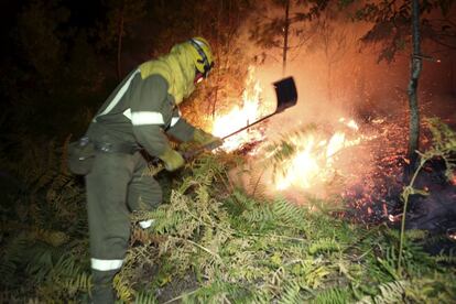 Brigadistas luchando contra el fuego durante la noche 