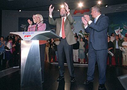 Mariano Rajoy, flanqueado por Teófila Martínez y Javier Arenas, en la convención del PP en Sevilla.