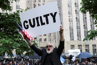 A man holds a placard outside Manhattan criminal court following the verdict in former U.S. president Donald Trump's criminal trial.