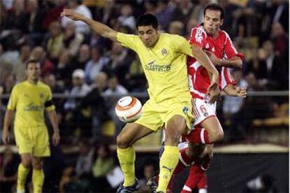 Riquelme intenta llevarse el balón ante Petit.