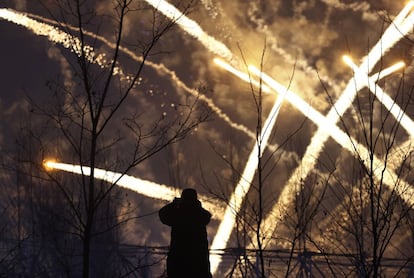 Un hombre fotografía los fuegos artificiales durante una celebración de los Juegos Olímpicos de Invierno 2018 en Pyeongchang (Corea del Sur).