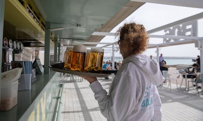 Una camarera sirve cervezas en un chiringuito en Palma, el 20 de marzo de 2025.