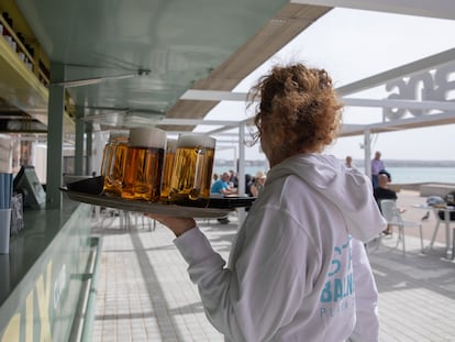 Una camarera sirve cervezas en un chiringuito en Palma, el 20 de marzo de 2025.