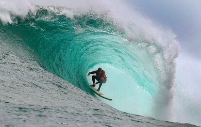 El surfista Mike Schlebach dentro del túnel de una ola junto a un arrecife, a las afueras de Ciudad del Cabo, Sudáfrica.