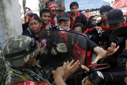 <i>Camisas rojas</i> intentan entrar en una estación de comunicaciones a las afueras de Bangkok, cercada por las fuerzas de seguridad tailandesas. Miles de manifestantes antigubernamentales llevan casi un mes en las calles para exigir la convocatoria de elecciones anticipadas.