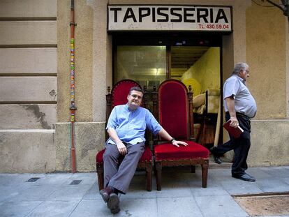 El escritor Sergi Pàmies ante una tapicería tradicional del Eixample de Barcelona.
