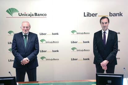 El presidente de Unicaja, Manuel Azuaga, a la izquierda, con el consejero delegado de Liberbank, Manuel Menéndez, durante la firma de la fusión este miércoles en Málaga.