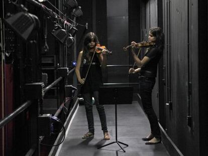 Dos chicas ensayan cn sus violines entre bambalinas, en el Teatro del Canal.